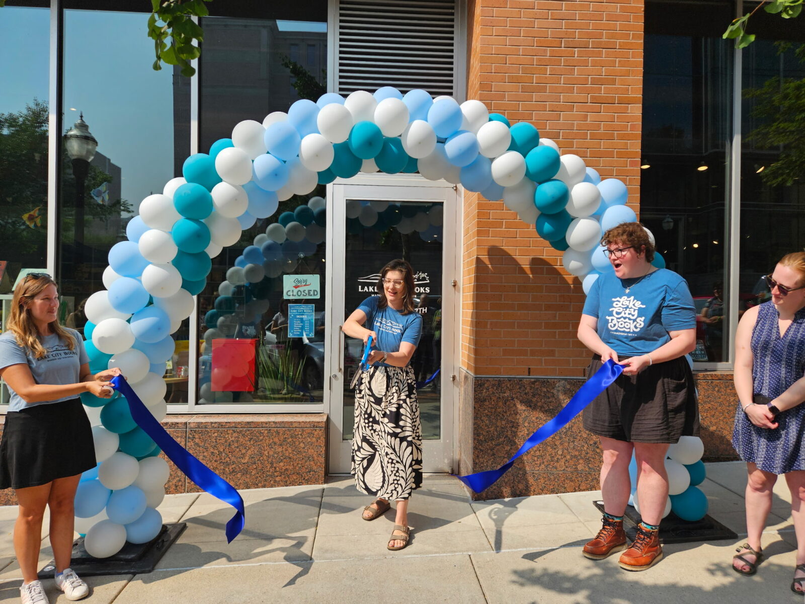Owner Molly Fish completes the ribbon cutting ceremony for the grand opening of the new Lake City Books location in downtown Madison.