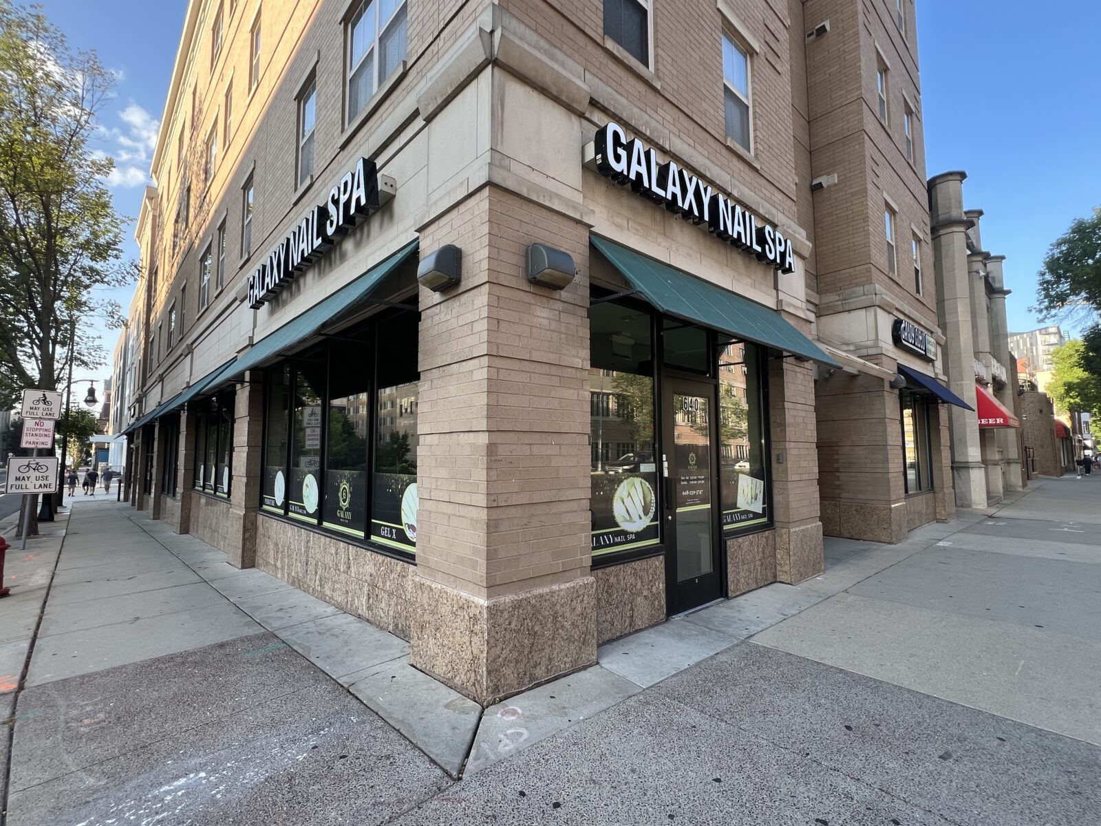 Image shows a corner commercial property labeled "Galaxy Nail Spa" that is a retail space below offices or apartments.